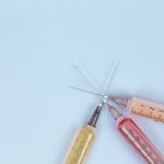 Three syringes on a light blue background