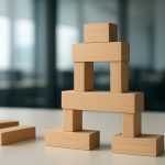 A carefully arranged structure made of wooden blocks on a table, symbolizing the foundation of business design.